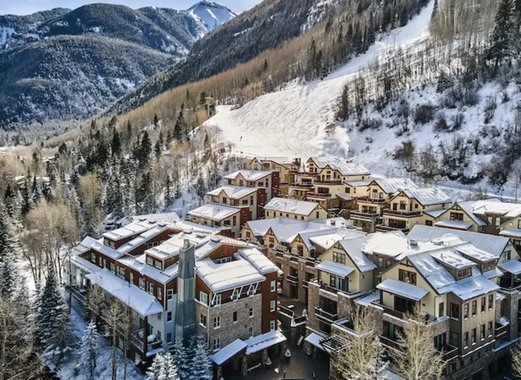 Aerial view of the Element 52, Auberge Collection Residences in Telluride, Colorado, featuring the building complex set against a backdrop of snow-dusted mountains.