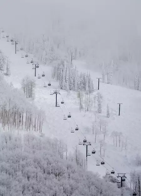Skiing Gondolas travel up a snow-covered mountain hill in Steamboat Springs